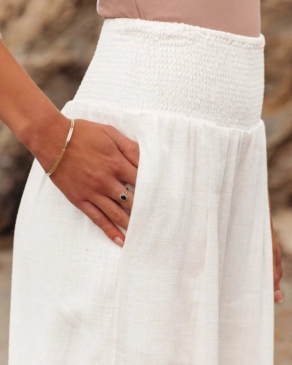 white high-waisted smocked wide leg pants with textured waistband and soft flowing fabric for women