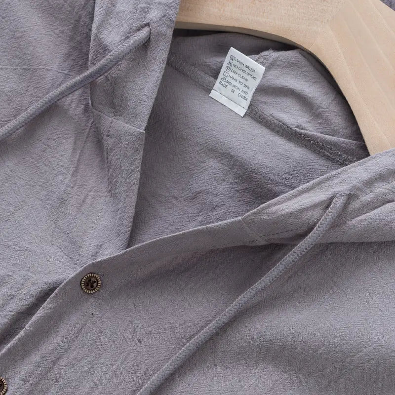 men’s gray linen blend sleeveless hooded button up shirt with subtle texture and decorative brass buttons