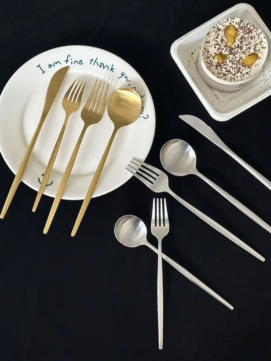 Gold and silver stainless steel matte cutlery set with sleek modern designs arranged on a white plate for minimalist flatware use.