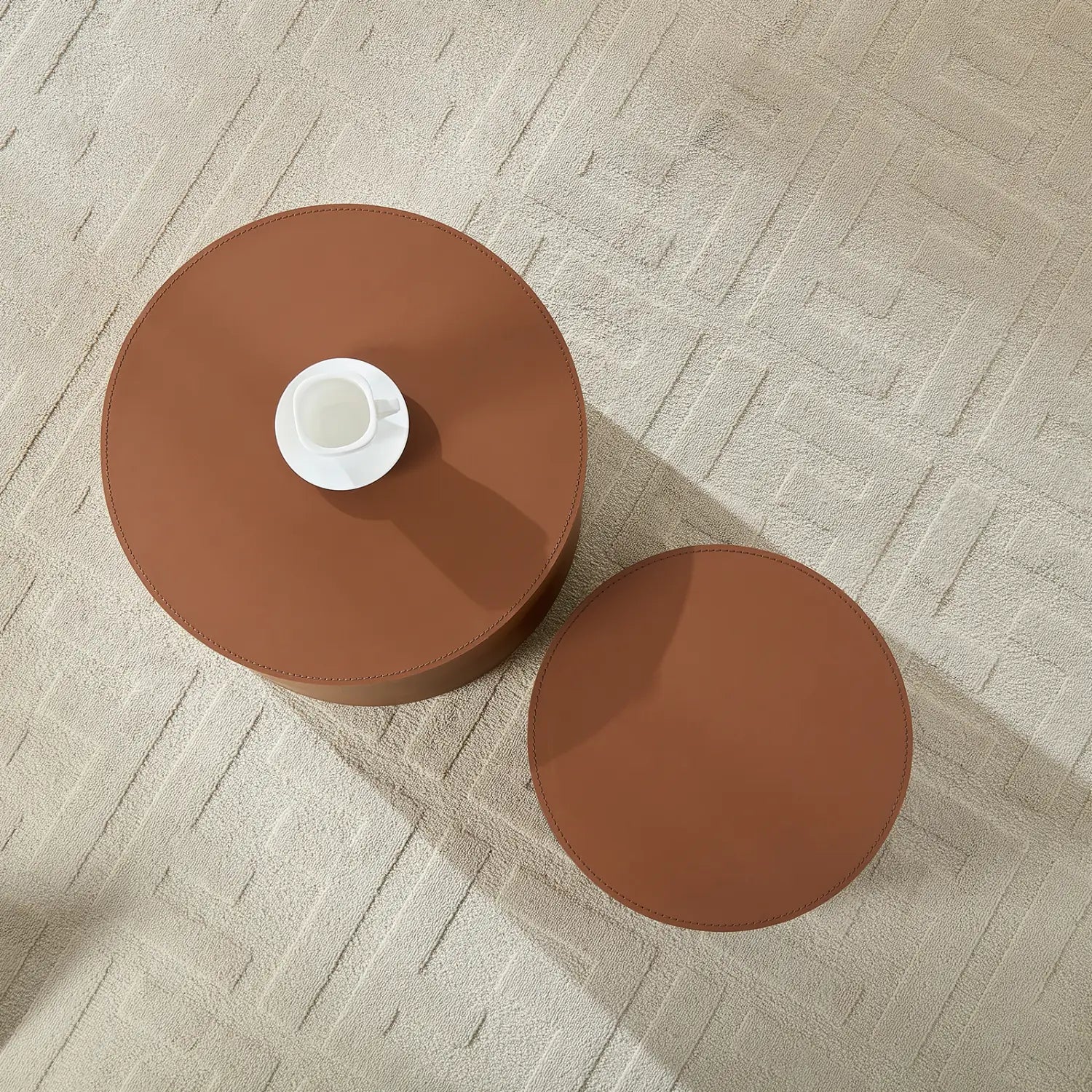 Juego de mesa de centro cilíndrica de cuero marrón tipo silla de montar, con mesas laterales redondas de cuero marrón y un diseño minimalista