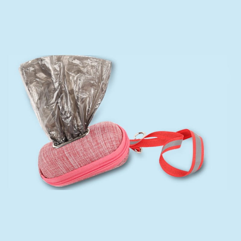 Pink textured fabric dog poop bag dispenser with a red reflective strap for pet waste management.