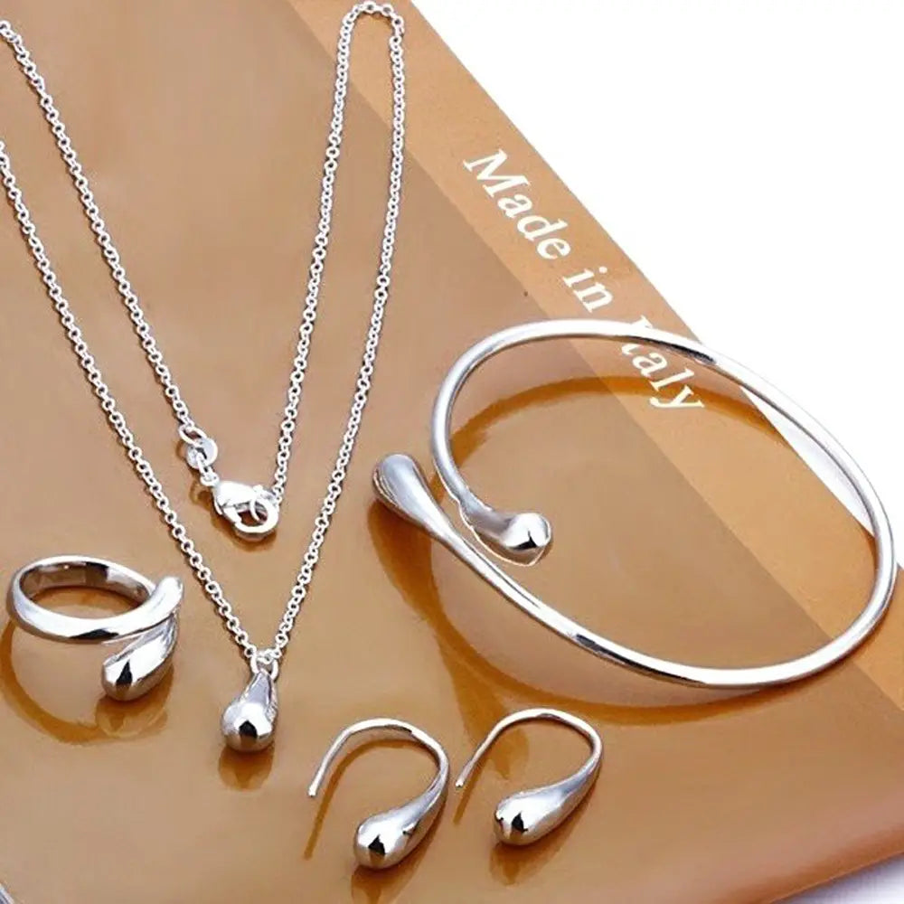 Modernes silbernes tropfenförmiges schmuckset mit gemischten accessorys, darunter eine kette, ein armreif, ein ring und ohrringe, mit eleganter polierter metallverarbeitung.