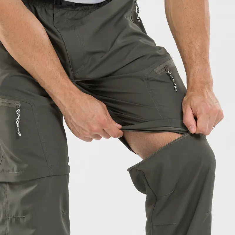 Olive green waterproof convertible tactical hiking pants with zippered side pockets and chain pulls designed for outdoor use.
