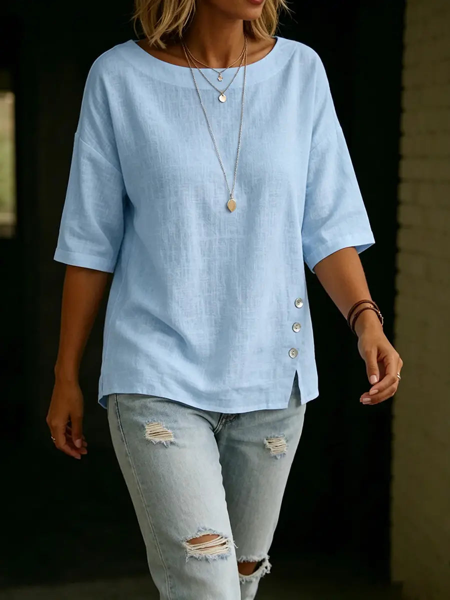 Light blue loose-fitting linen casual top with three-quarter sleeves and asymmetrical button details along the side seam