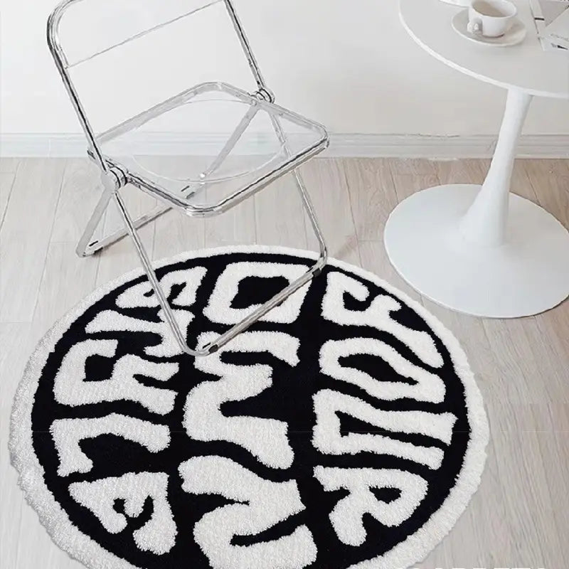 Black and white round plush rug featuring bold fluffy lettering spelling your in a modern font for minimalist decor use.