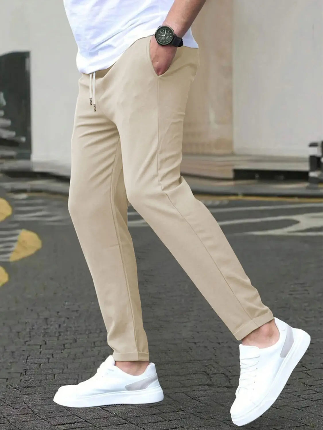 Beige slim fit tapered jogger pants with drawstring waistband and subtle side pockets designed for casual comfort.