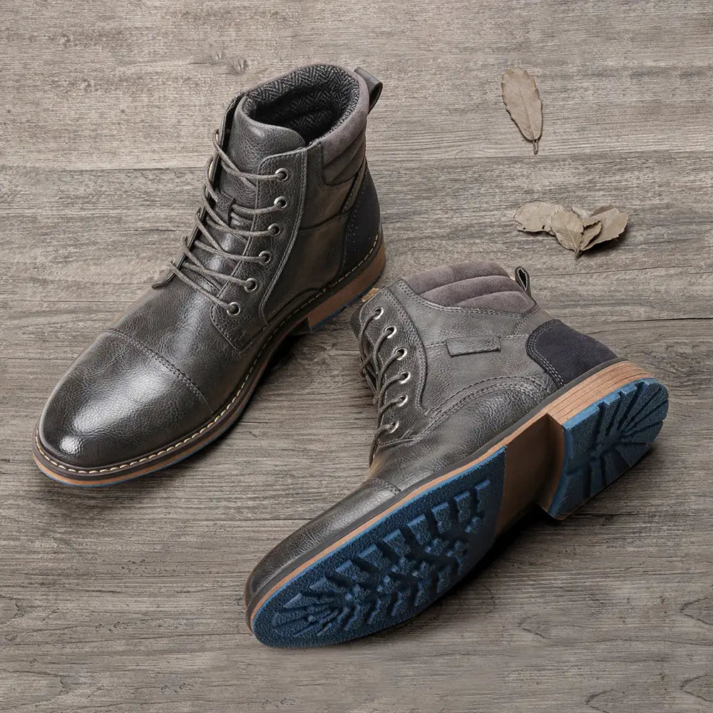 Men’s leather martin boots featuring dark gray leather, tan stitching, and contrasting blue rubber lace-up soles.