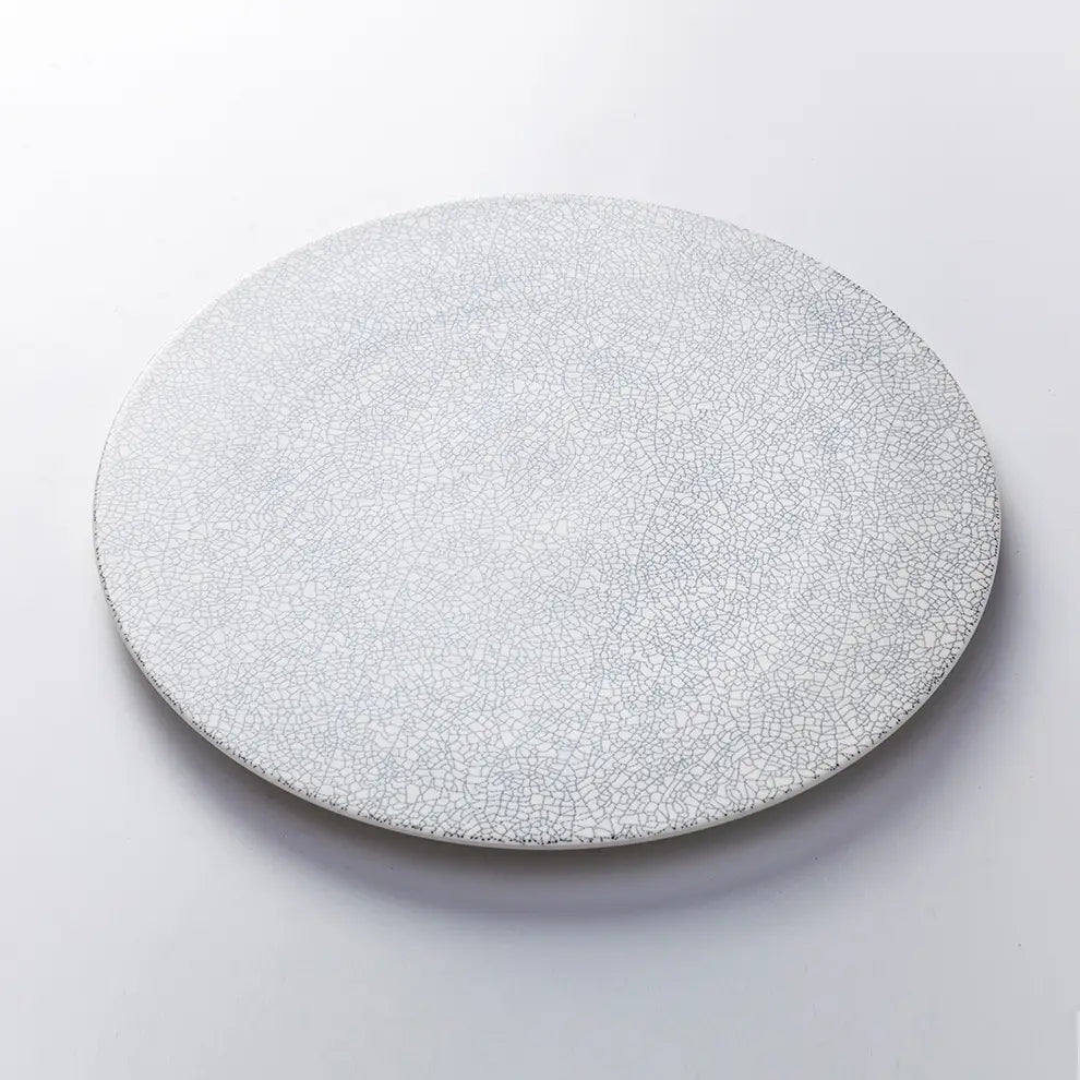 Una placa de cerámica circular blanco crackle Lucerne Sophie en un tono gris claro con un acabado delicadamente craquelado.