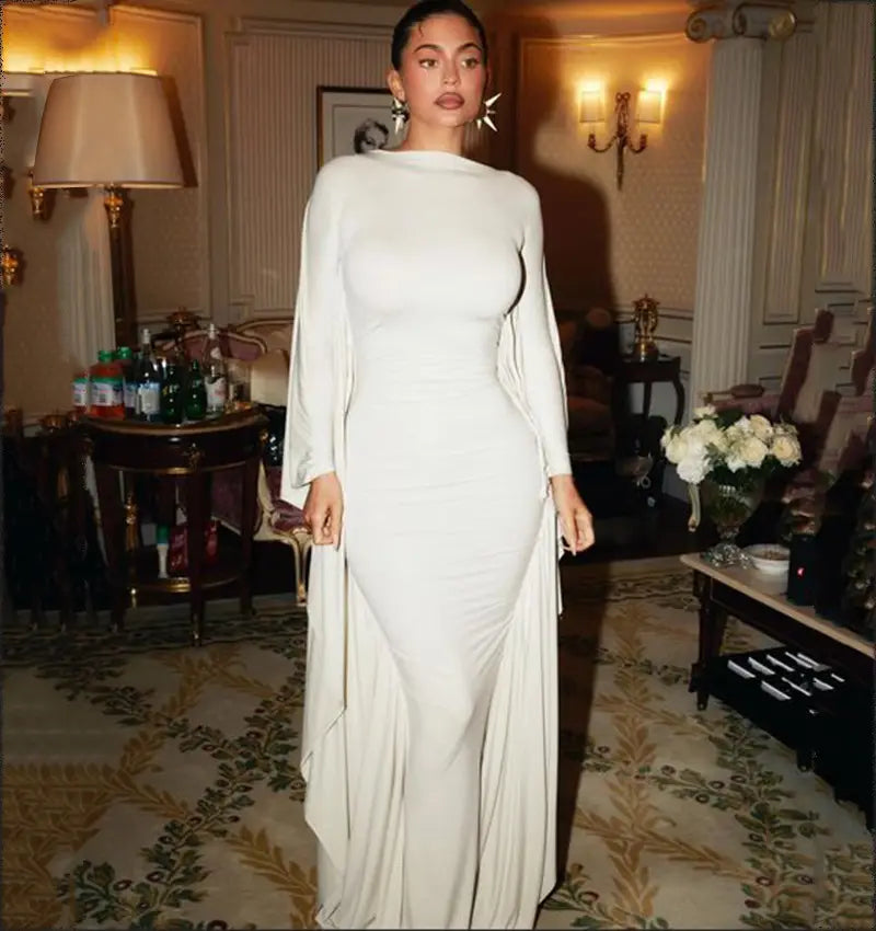 A sleek off-white satin asymmetrical batwing sleeve maxi dress with long flowing sleeves and a high neckline.