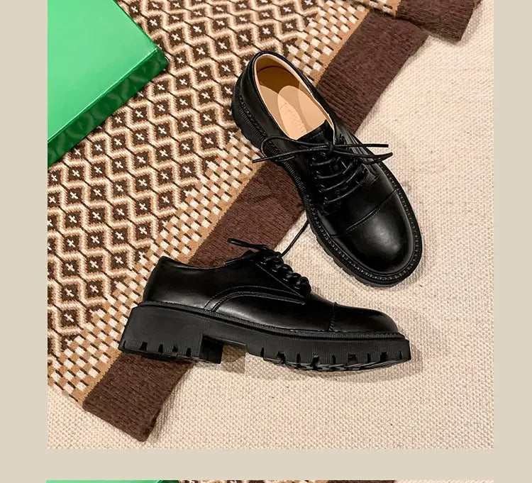 Schwarze Leder-Schnür-Oxfordschuhe mit grob strukturierter Sohle aus Rinderleder, die ein Design im britischen Stil zur Schau stellt