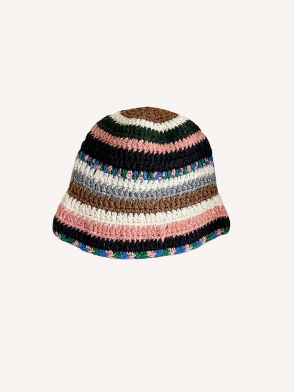 Un chapeau de pêcheur multicolore tricoté à la main, avec des rayures horizontales dans des tons naturels de marron, noir et rose, et des accents verts et bleus le long du bord.