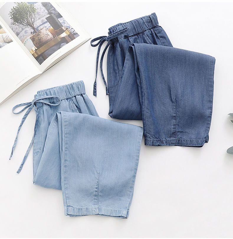 light blue denim harem jeans high waisted drawstring pants with elastic waistband and drawstring closure.