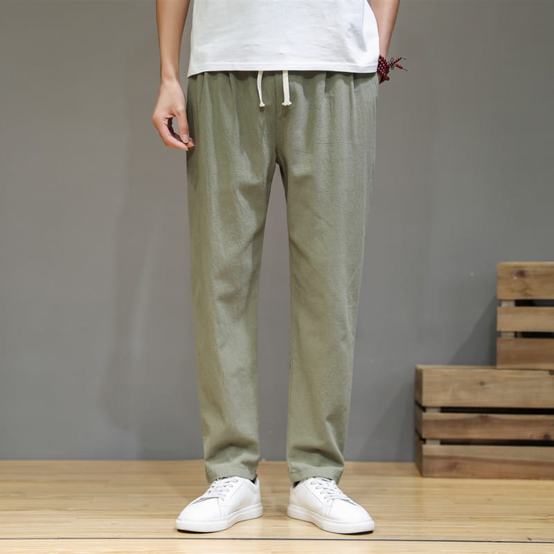 Herren-Slim-Fit-Jogginghosen aus olivgrünem Baumwoll-Leinen mit weißem Kordelzugbund, von vorn abgebildet.