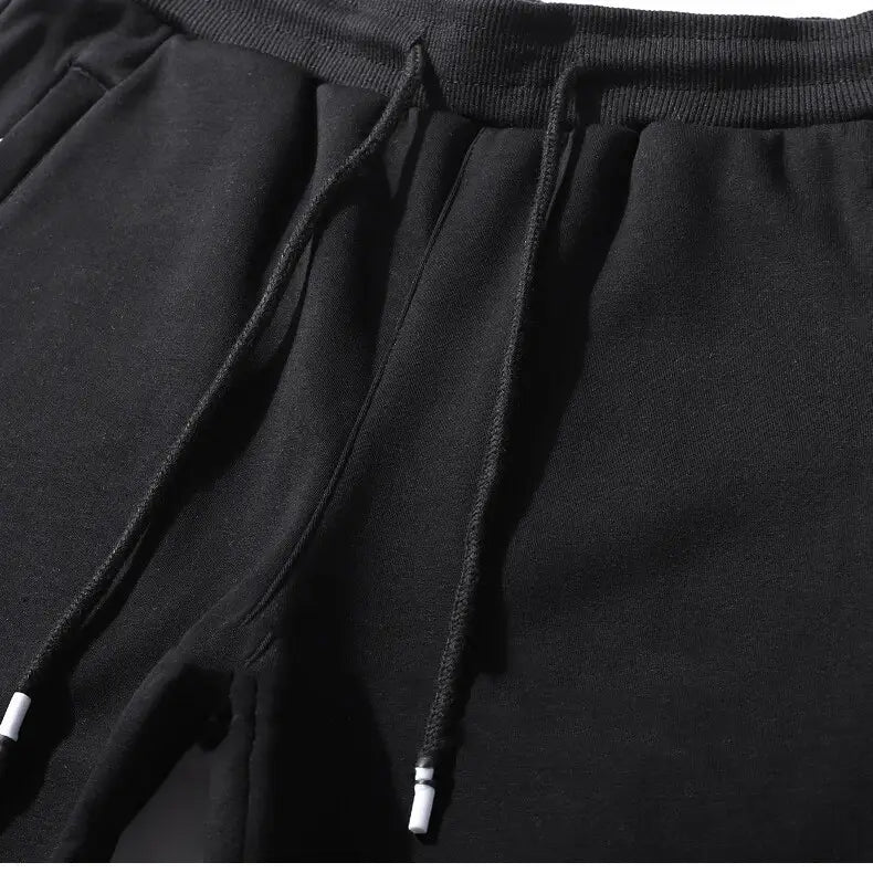 Men fleece lined joggers straight leg cotton sweatpants in black with ribbed waistband and white aglets on the drawstring cords.