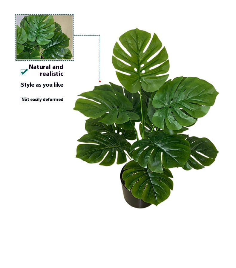 A lush deep green artificial monstera turtle leaf potted plant with glossy perforated leaves in a sleek black pot for garden decor.