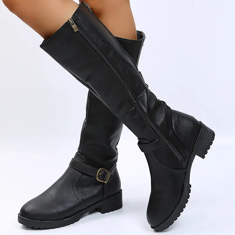 Black leather knee high knight boots with a matte finish featuring a side zipper and an adjustable ankle strap with a gold toned buckle.