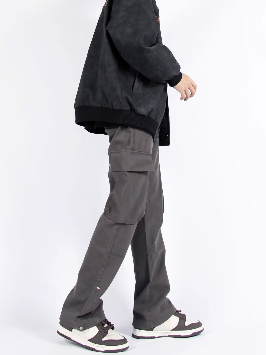 Pantalones cargo grises oscuros de pierna recta con múltiples bolsillos, con ajuste relajado y tejido resistente, diseñados para una utilidad funcional.