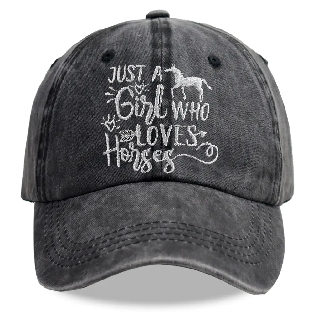 A faded black distressed denim baseball cap featuring white embroidered text just a girl who loves horses and a horse silhouette.