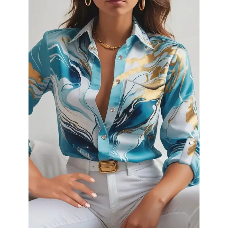 A women’s marble print satin long sleeve button blouse in shimmering turquoise and gold with a classic collar and rolled-up sleeves.