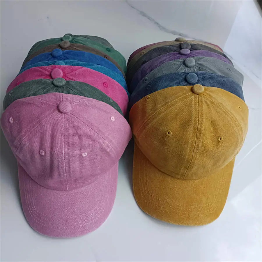 A soft muted pink cotton baseball cap made of corduroy fabric with a matching button closure, designed as a vintage washed sun hat.