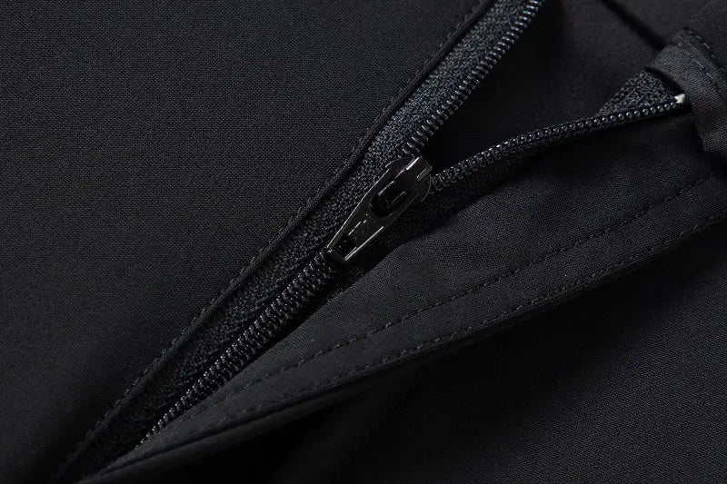 Men plus size stretch casual pants detail showing a black zipper with a sleek metallic pull tab set against dark fabric.