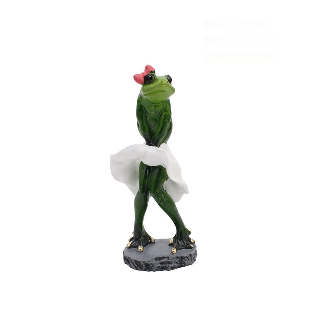 Grüne Frosch-Resinfigur mit einer rosa Schleife und weißem Rock, die auf einer grauen Basis für skurrile Wohnaccessoires-Statuen steht.