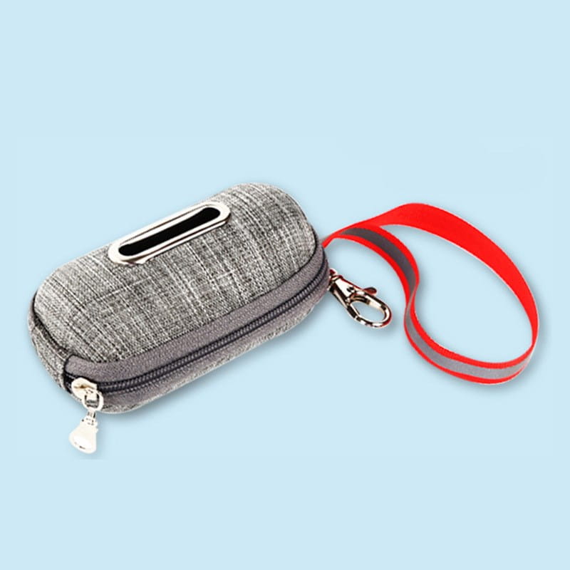 Gray textured fabric dog poop bag dispenser with a red reflective strap and silver metal clasp for pet waste management.