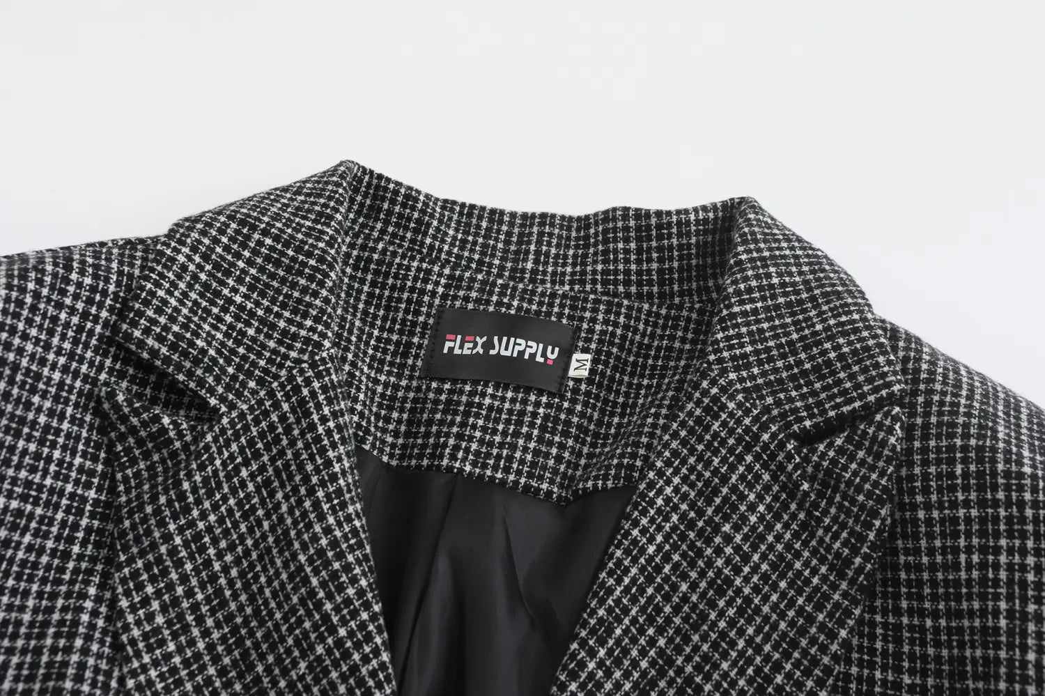 Men’s double breasted knit blazer in black and white houndstooth pattern with flex supply brand label.