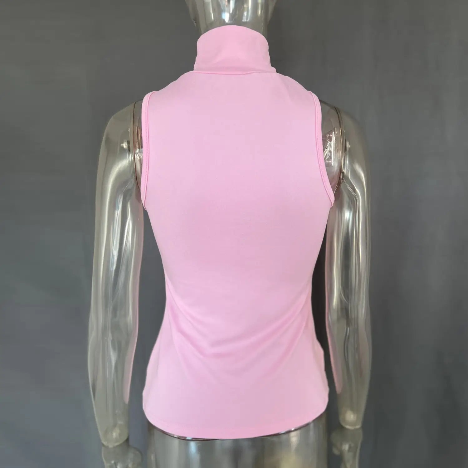 A soft pink gold ring halter stretch top featuring a sleeveless high-neck design made from smooth, stretchy fabric.