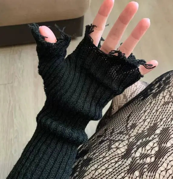 black tattered knit fingerless gloves unisex with ribbed texture and frayed edges made of black knitted material shown from the back side