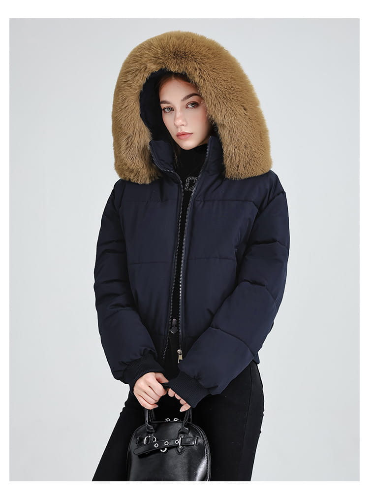 Dunkelblaue Damen-Fell-Kapuzensteppjacke mit einer braunen Fell-innenkapuze und wattierter Isolierung für kaltes Wetter.