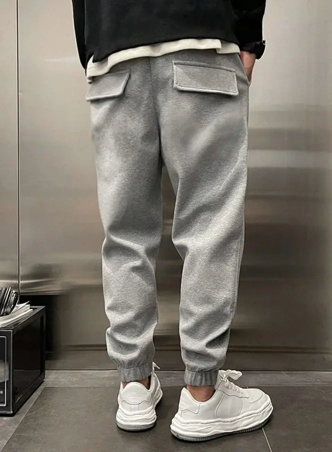Men’s gray fleece drawstring sweatpants featuring two front pockets and elastic cuffs for comfort and warmth.