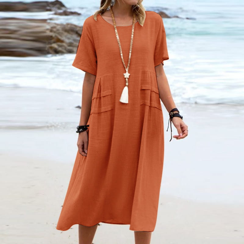A flowing orange linen midi beach dress with short sleeves and tiered pockets for women.