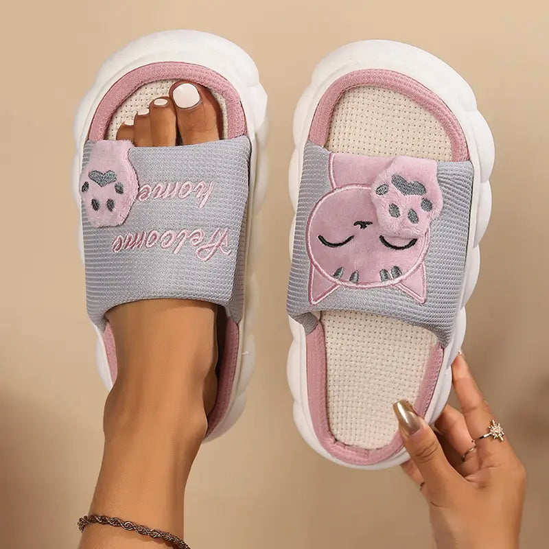 Pink and gray cat-themed unisex slide slippers with plush embroidered cartoon design and anti-slip soles.