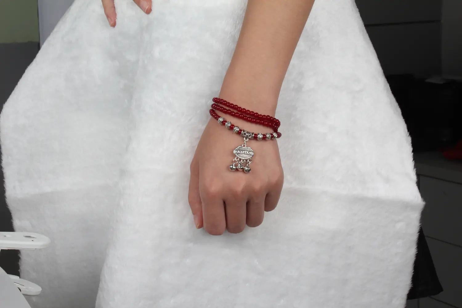 Red agate good luck bracelet featuring red beads and a silver-toned skull engraved protect charm.