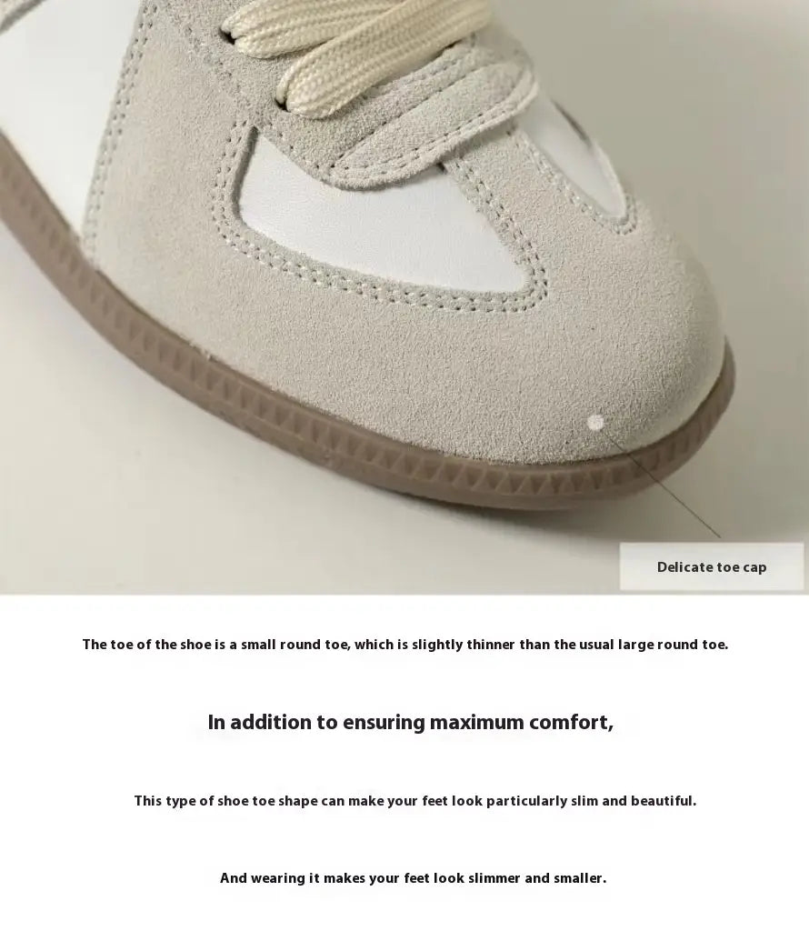 Ein hellgrauer Veloursleder-Sneaker aus Leder mit einer weißen Gummikappe an der Spitze und passenden Schnürsenkeln, entworfen als vielseitige Freizeitschuhe im Low-Top-Design.