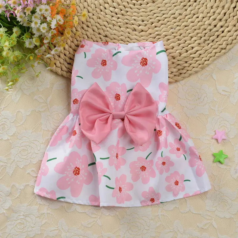 Pink floral-patterned dog princess dress made of satin with a matching bow at the waist for strawberry daisy pet apparel.