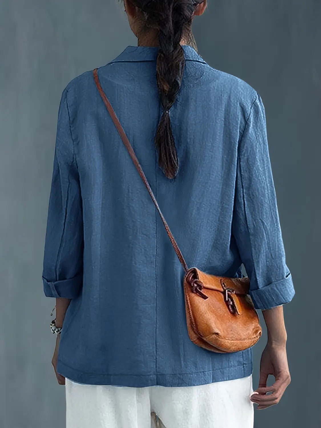 Bolso cruzado de cuero color camel con cierre de hebilla y correa ajustable, combinado con blazer de lino para mujer, casual y de trabajo.