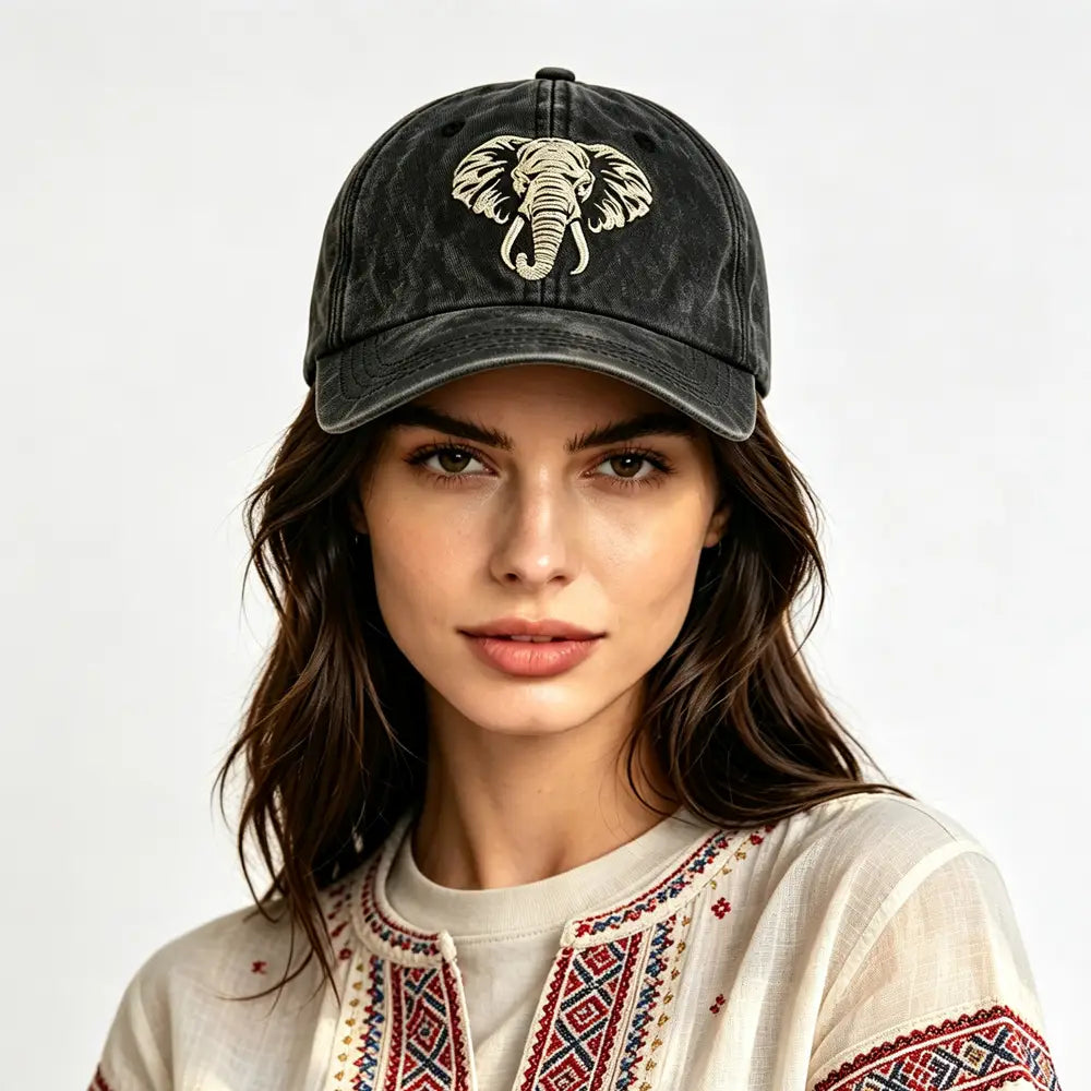 Black distressed vintage washed cotton baseball cap with cream and beige embroidered elephant design on the front.
