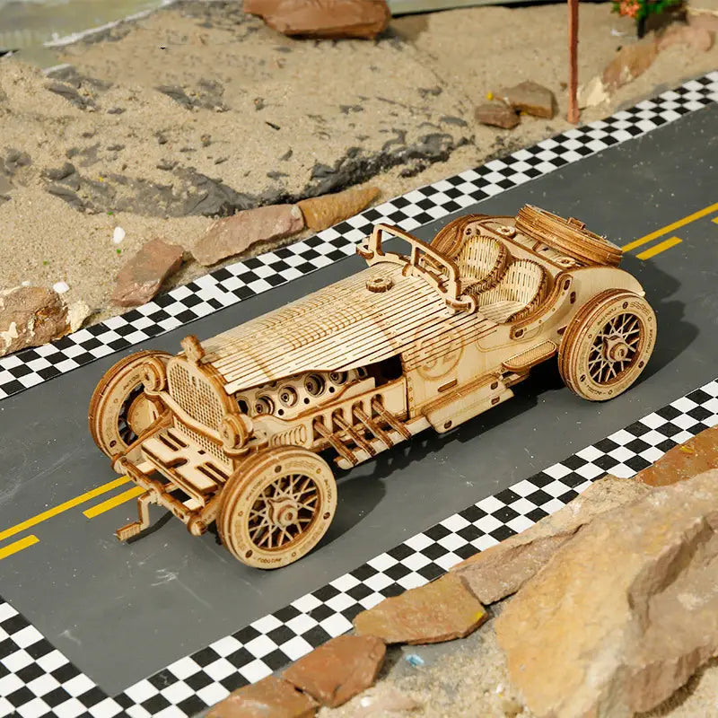Un kit de construction de modèle mécanique 3D d’assemblage DIY en bois, finement conçu, représentant une voiture de course vintage, avec des composants de moteur détaillés et des roues à rayons.