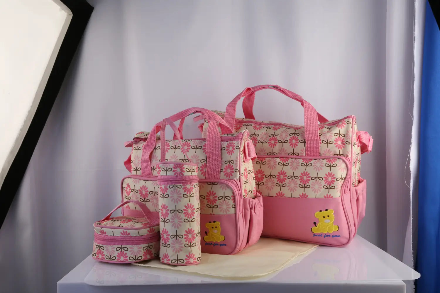 pink floral-patterned water-resistant 5-piece baby diaper bag travel set with yellow bear appliqués and matching pink handles