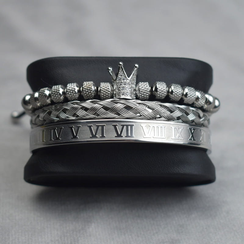 Silver-toned crown royal diamond beaded bracelet set with textured beads, braided bands, and a sleek metal cuff engraved with roman numerals.