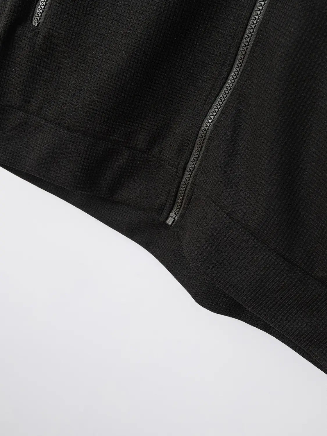 Black waffle knit zip cardigan jacket featuring textured fabric and a sleek silver zipper.