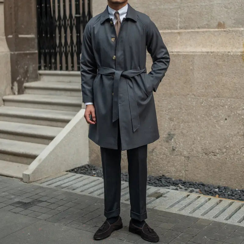dark gray wool winter trench coat with a single-breasted buttoned front, classic collar, and belted waist.