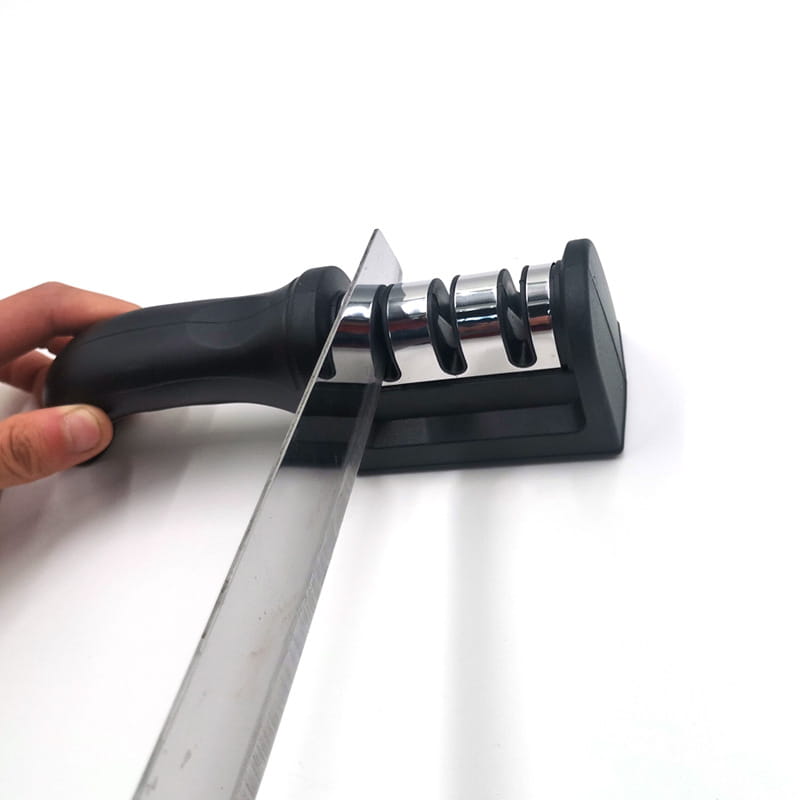 Aiguiseur de couteaux à manche noir avec trois étapes abrasives en chrome pour une utilisation manuelle en cuisine.