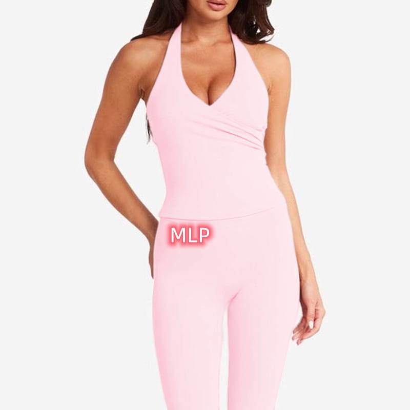 A soft pink form-fitting halter neck one-piece athletic suit with a draped front detail paired with pink high-waisted fitness leggings.