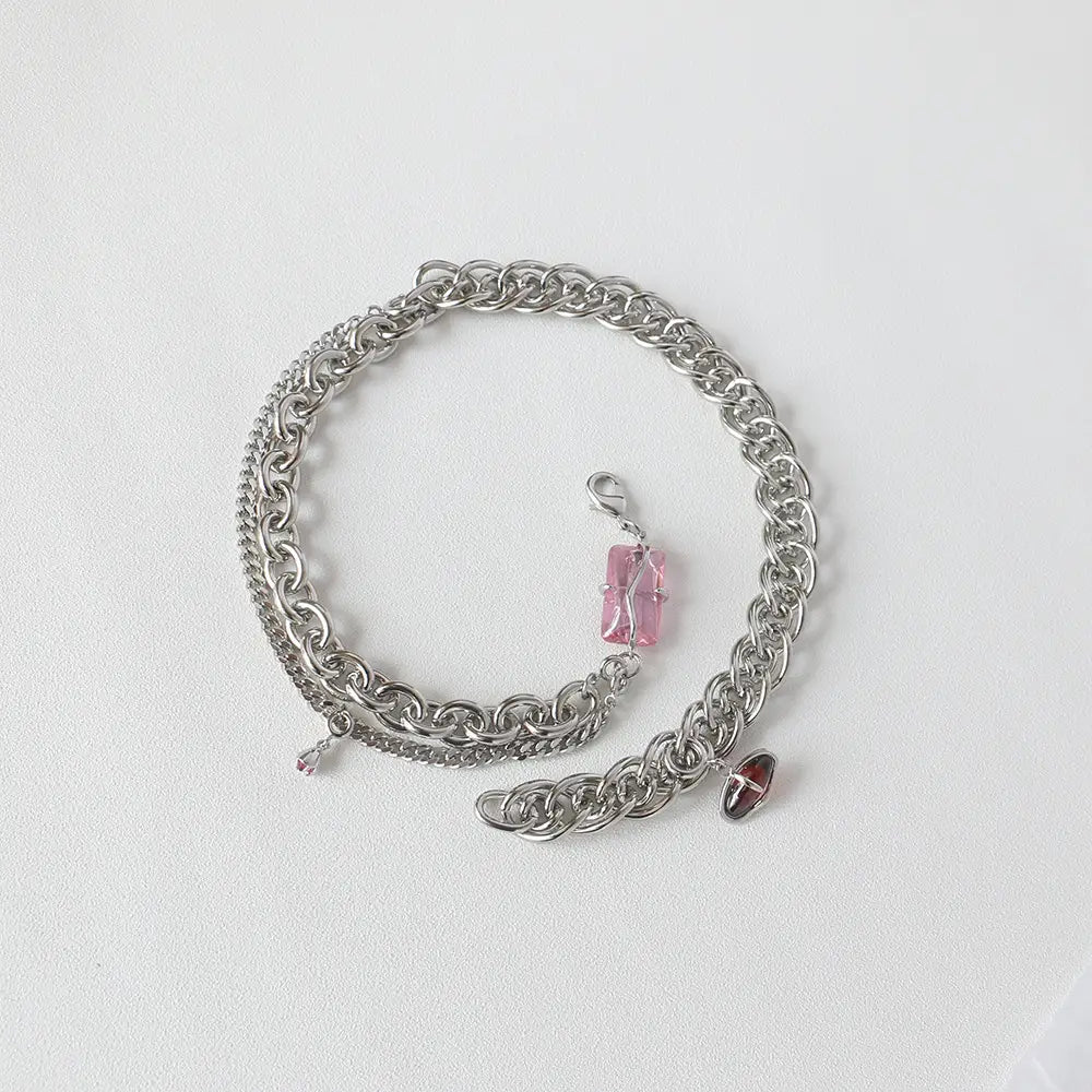 Silver chain bracelet featuring a pink crystal pendant and a red enamel charm designed to complement a layered silver opal and zircon crystal charm necklace.