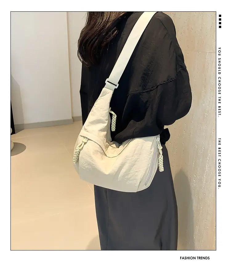Off-white nylon large capacity crossbody hobo shoulder bag with canvas material white braided tassels and a matching adjustable strap.