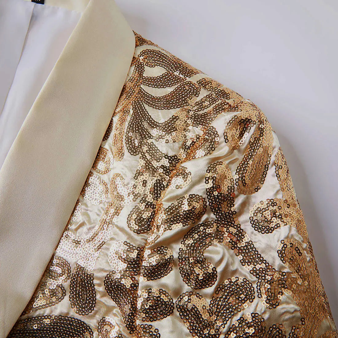 A shimmering gold and cream sequined mens suit jacket with a satin lapel featuring a retro floral blazer design.