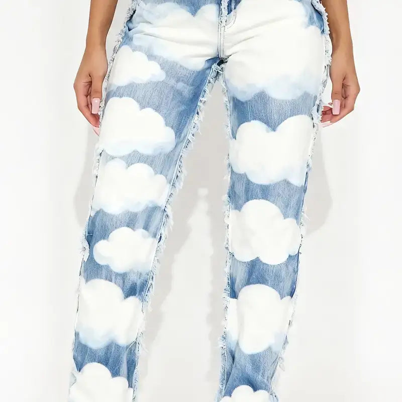 Straight leg medium wash blue denim jeans feature a whimsical white cloud print, high waist, geometric design, and distressed frayed edges.